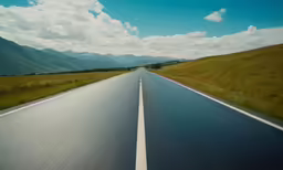 a paved road that is surrounded by mountains and hills