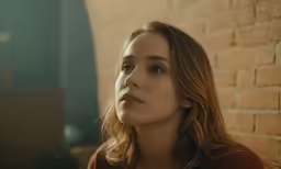 the woman is looking off to the side with brown eyes