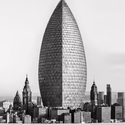 a big building with a very tall tower and city buildings