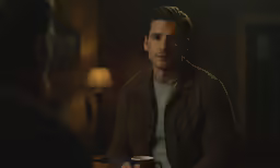 a man sitting down with a coffee mug