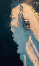 an old red pick up truck driving down a dirt road