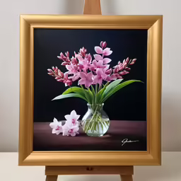 a vase with pink flowers is sitting on a easel