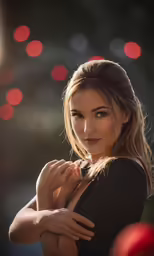 a young woman posing for a portrait, with red boke lights in the background