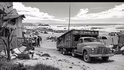 a black and white photo of a truck and people,an old truck sits on a beach near the ocean