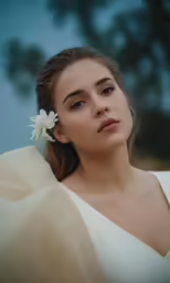 a woman in white and with a flower on her head