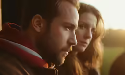 two people staring at the camera in an outdoor setting