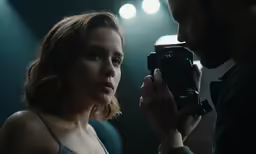 a woman holding up a camera next to a man