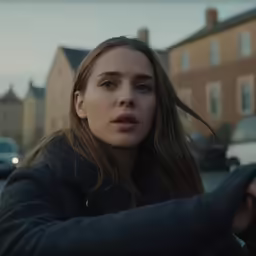 a beautiful young woman wearing black holding onto the handle of her car
