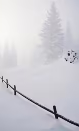 a fence on a snowy hill is covered with snow