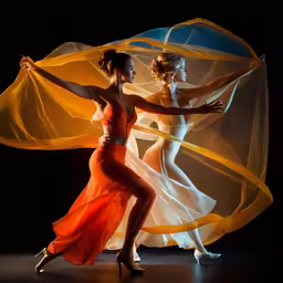 two young women wearing orange and white dance outfits