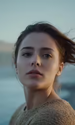 the woman is looking at the camera while standing outside