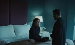 two people in a bedroom talking to each other