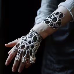 someone wearing black and white gloves holding on to their arm
