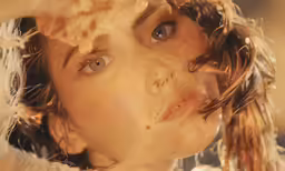 a young woman looks up as she stares into the distance