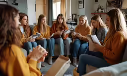 girls sitting on couches with notebooks in hands