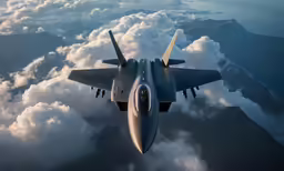 a military plane flies in the air above clouds