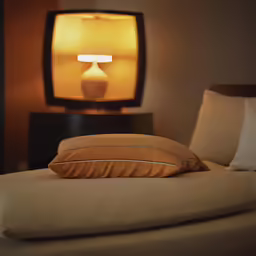 pillows are on a bed next to a television