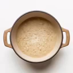the soup is being prepared and served in the pot
