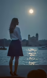 a woman in a skirt looking out over the water