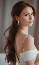 beautiful young girl posing while wearing her wedding gown and earrings