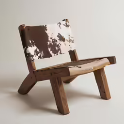 a chair with two leather straps and a cow hide print seat
