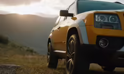 yellow vehicle parked in a mountainous area with a view of the mountains