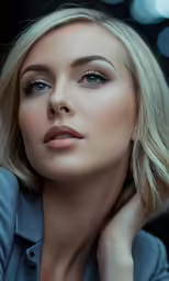 a blonde woman with a blue collared shirt and grey eyeshadow
