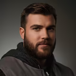 a bearded man wearing headphones looking to the side