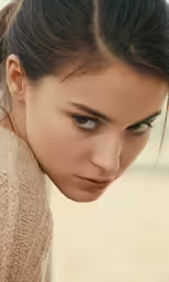 a woman in a sweater staring at something