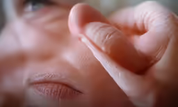 a close up of someones nose and fingers