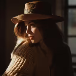 woman in large hat with hair down looking to the side
