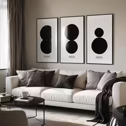 three paintings hang on a wall in a living room