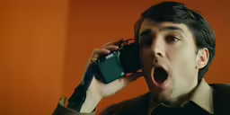 an young man is talking on his cell phone