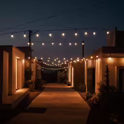 several rows of lights strung over a sidewalk