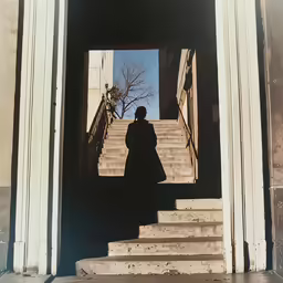 someone standing in front of the stairs to a building