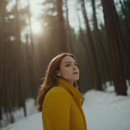 a woman looking up in the trees at the sun
