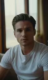 there is a man sitting at a table looking in a mirror
