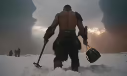 a man walking on a snowy surface holding two large shovels