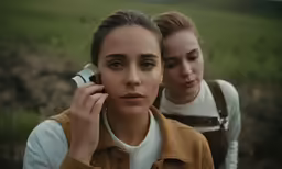 two beautiful young ladies walking and talking on cell phones