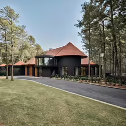 a house surrounded by tall trees and a forest
