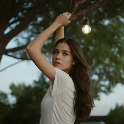 a girl on a branch with a lightbulb hanging from her head