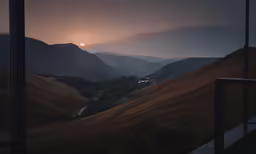 view out of window overlooking valley at sunset