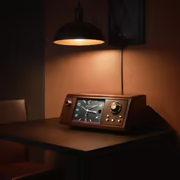 a clock on a table with lights above