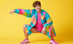a young person poses for a photo in brightly colored clothes