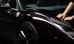 black car in front of a dark background with the hood up