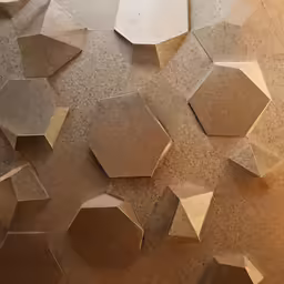 several hexagonal objects sit on a stone surface