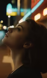woman staring at the sky outside a restaurant at night