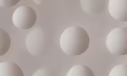 a close up of an arrangement of small white balls