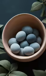 small rocks in a wood bowl with some leaves around it