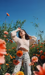 a woman in high rise jeans poses in a field of flowers
